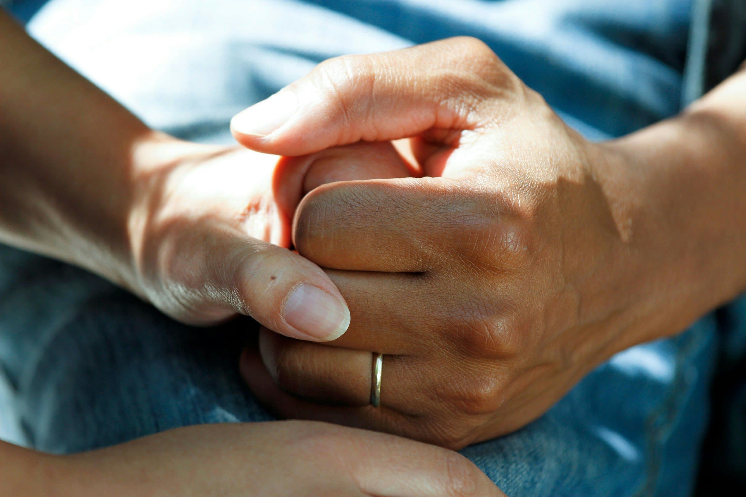 One person holding another person’s hand in support